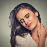 tired woman massaging her painful neck - Colorado Center of Orthopaedic Excellence pain management
