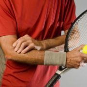 tennis player massaging elbow - Colorado Center of Orthopaedic Excellence tennis elbow