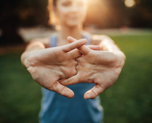 Young woman stretching arms outdoors