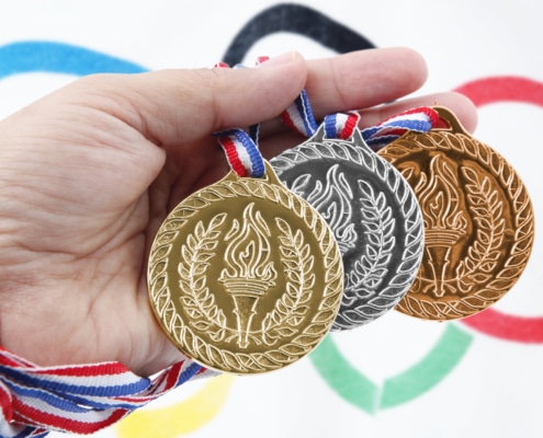 Three medals with Olympic Flag - Colorado Center of Orthopaedic Excellence USA Olympic Training Center