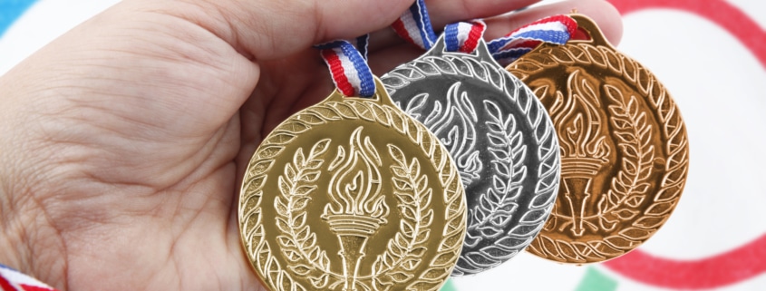 Three medals with Olympic Flag - Colorado Center of Orthopaedic Excellence USA Olympic Training Center